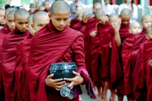 AMARAPURA, MYANMAR - JUNE 28, 2015: Buddhist monks queue for lunch in Myanmar