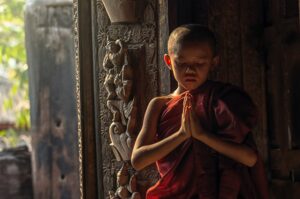 Buddhist novice praying at Shwenandaw pagoda, mandalay, myanmar