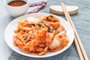 Kimchi cabbage. Korean appetizer on white plate, horizontal