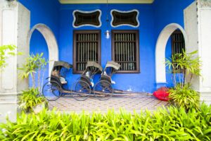 Rickshaws Against the Blue Walls of Cheong Fatt Tze Mansion, in George Town, Penang, Malaysia, South